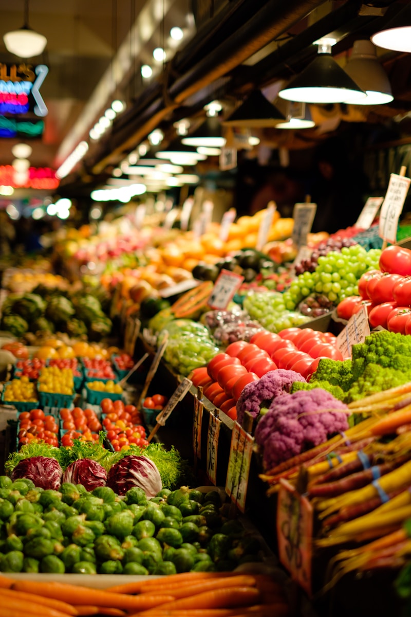 A colorful spring farmers market with produce overflowing under warm lights
