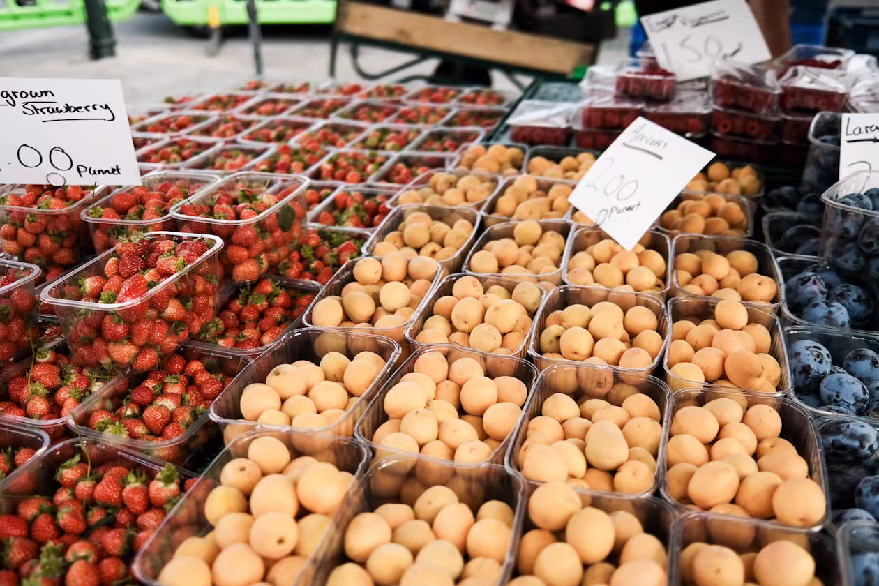 Fresh strawberries and spring fruit at a farmers market display